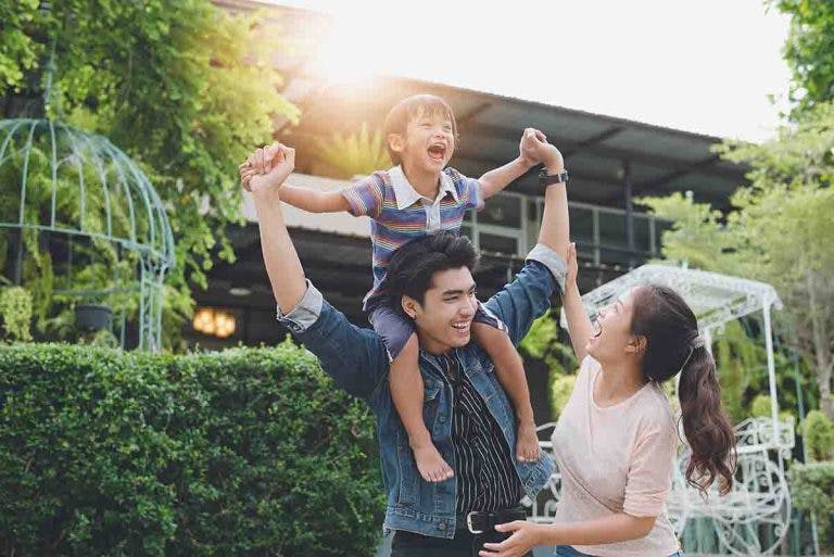 Young Asian parents play with their son in an outdoor setting