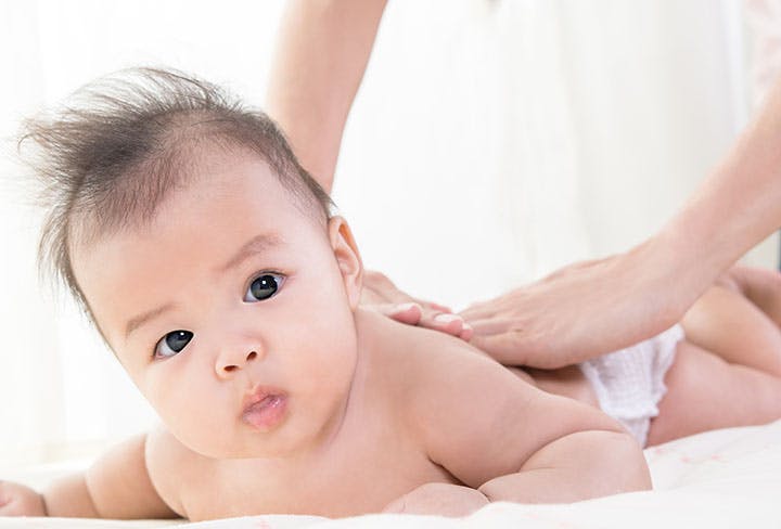 Physician gently massaging a baby’s back