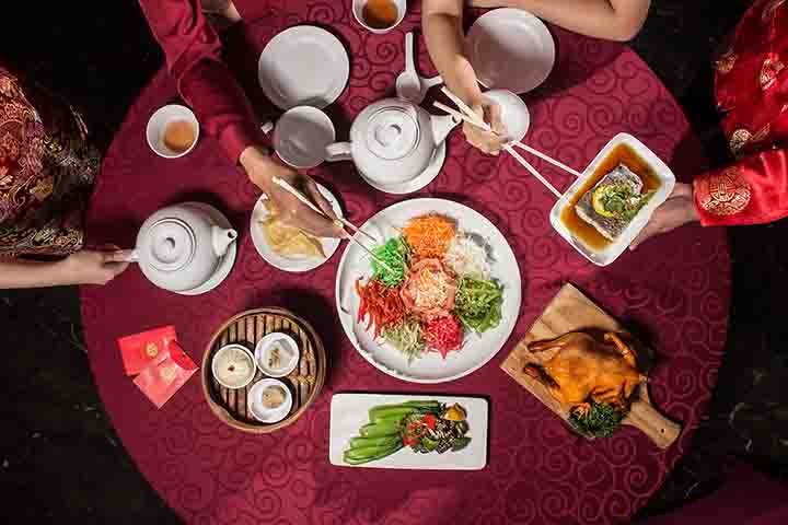 A Chinese New Year meal comprising a variety of dishes and Yee Sang