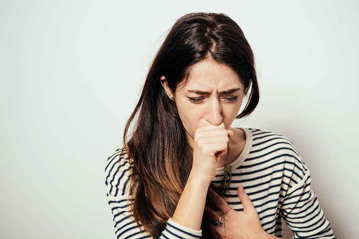 A girl coughing into her closed palm