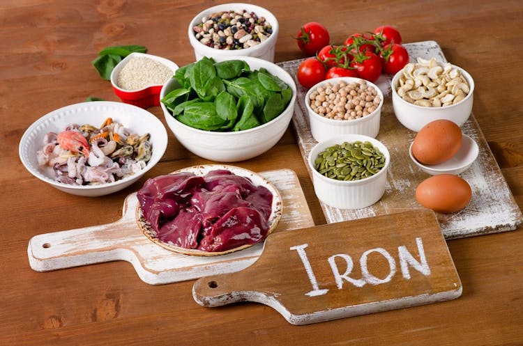 Vegan diet foods high in iron, including eggs, nuts, spinach, beans, seafood, liver, sesame, chickpeas, tomatoes