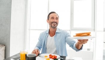 A man having a gluten-free diet breakfast while refusing to eat the bread