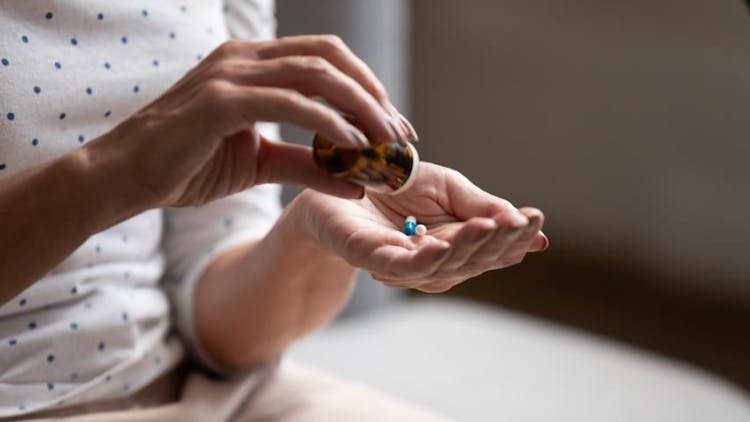 A woman pouring her medication for depression symptoms on her palm
