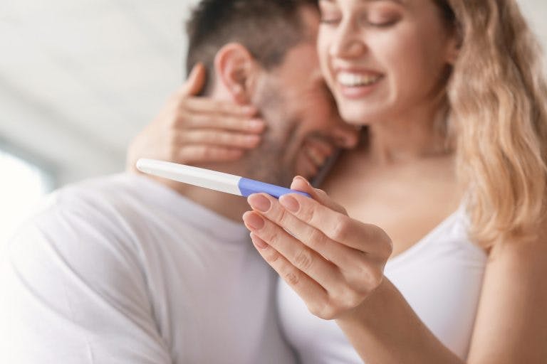 A couple hugging happily as they saw the positive pregnancy test