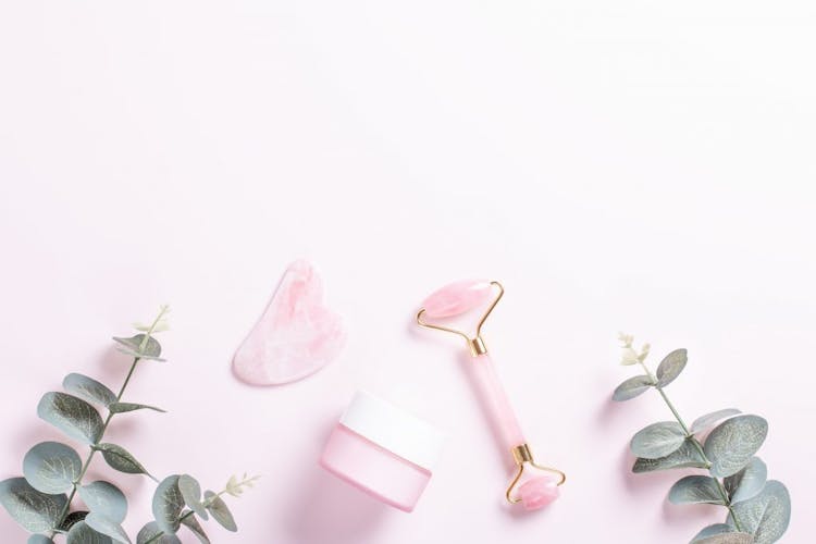 Gua sha tools pictured on a pink background 