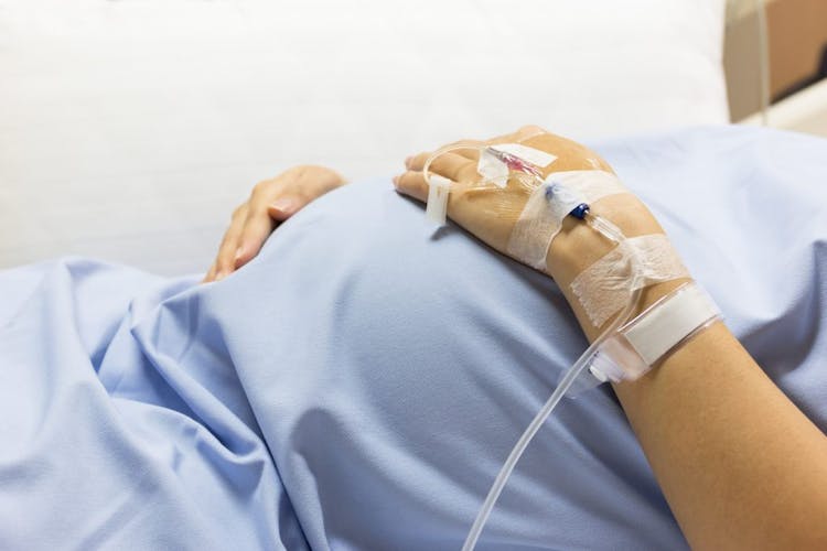 A pregnant woman receiving an IV in the hospital before birth 