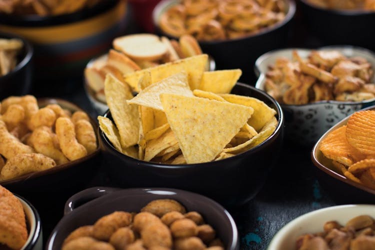 An image of salty, processed foods such as tortilla chips, potato chips, and pretzels