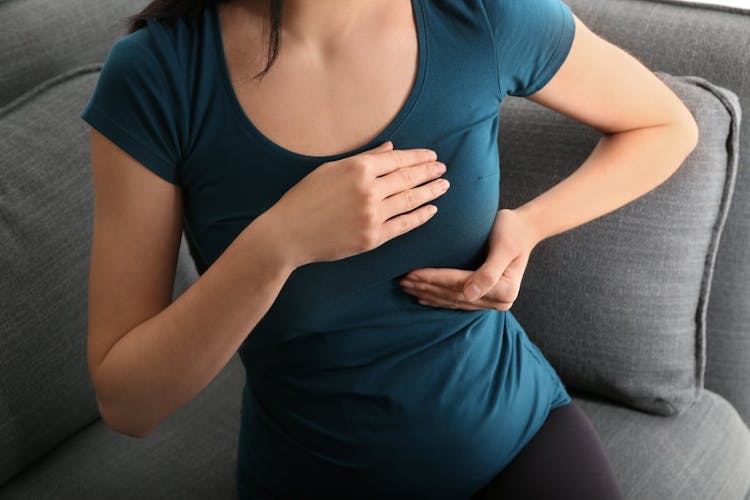 A woman holding and massaging her breast