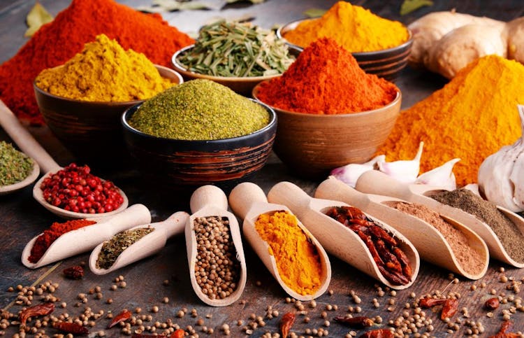 An image of colorful herbs and cooking spices on a wooden background
