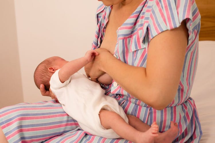 A woman latching her newborn baby during a breastfeeding session