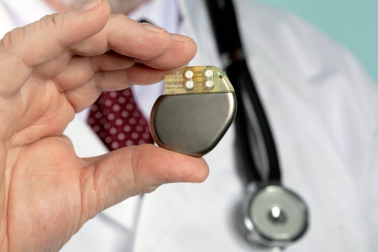 A doctor holding a pacemaker of the heart