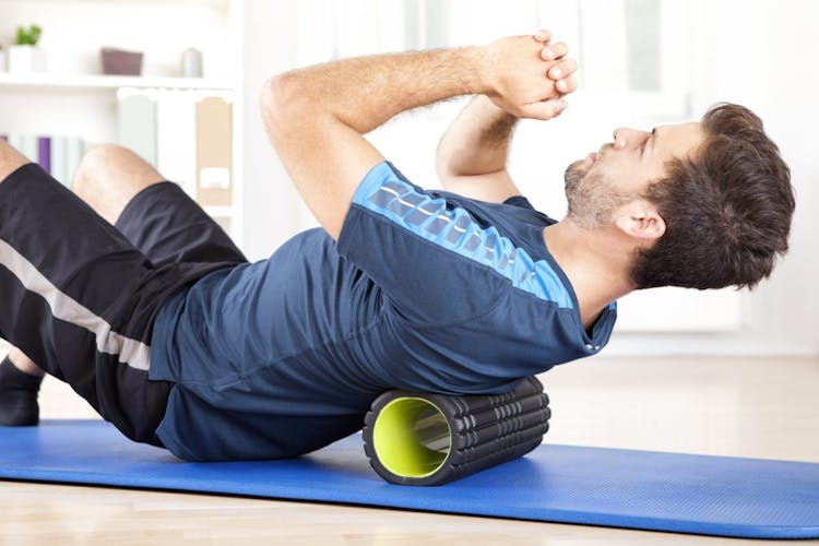 A man using a foam roller to reduce back pain