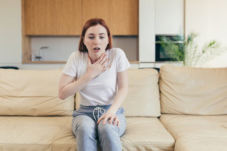 A woman sitting on her couch having an anxiety attack
