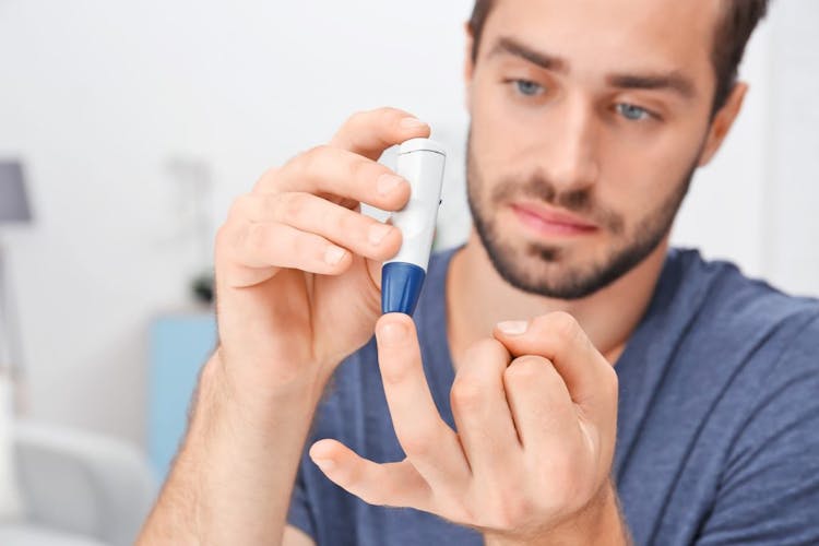 A man in a blue shirt checking his blood sugar levels