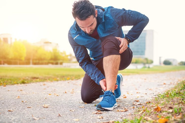 A male runner experiencing ankle pain
