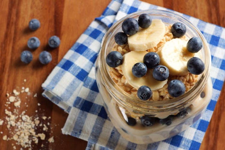An image of overnight oats in a mason jar with fresh blueberries and bananas