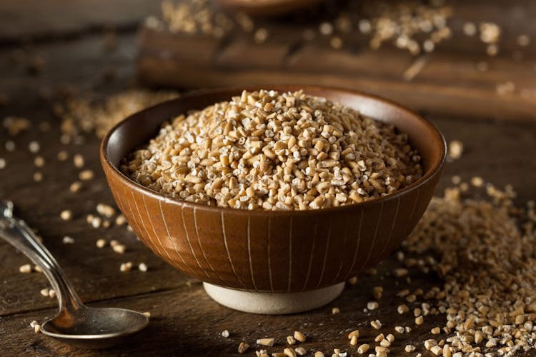 An image of steel cut oats in a brown wooden bowl