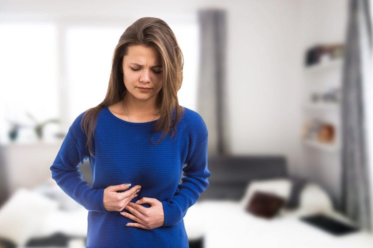 A young women pressing into her stomach in pain