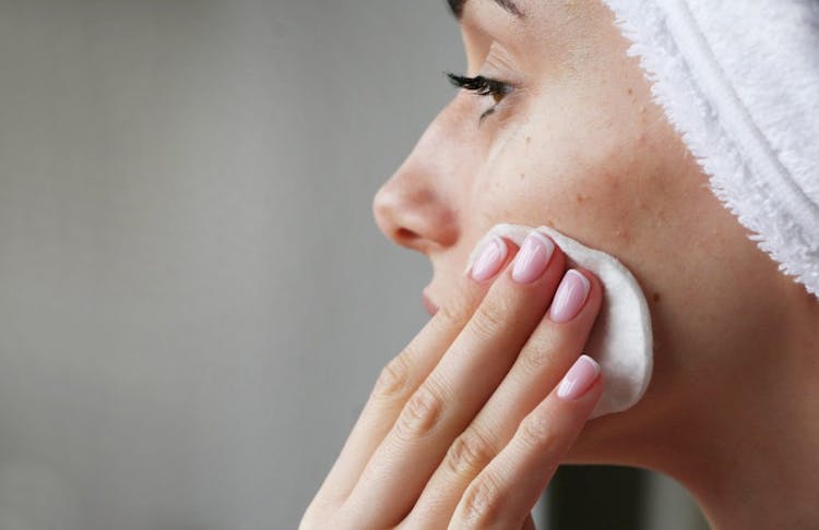 A woman using acne products on her skin