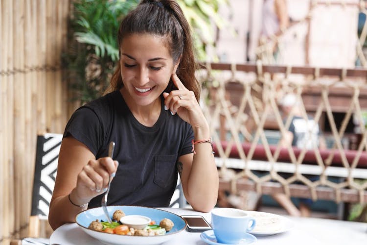 A smiling woman eating a healthy meal 