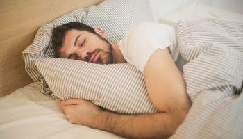 Man sleeping soundly and hugging a pillow
