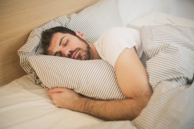 Man sleeping soundly and hugging a pillow