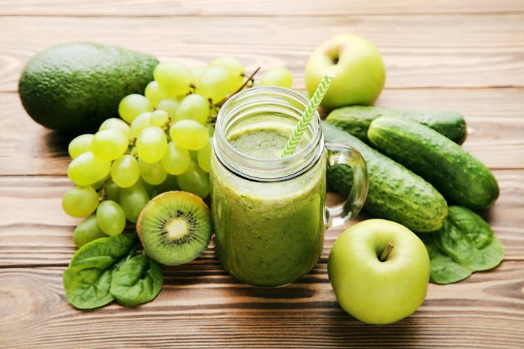 A green smoothie with grapes, apples, kiwis, cucumbers, and avocados