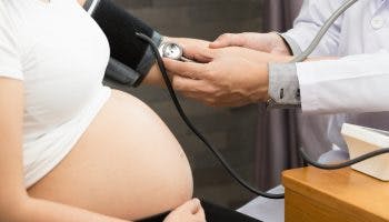 A doctor takes a pregnant woman's blood pressure