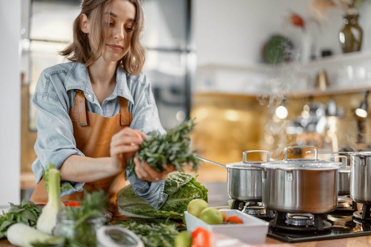 A woman cooking leafy green vegetables for healthy diet