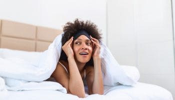 A woman waking up in the morning, free from types of sleep disorders