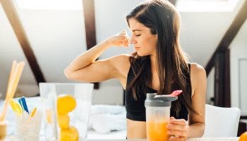 A woman with a strong immune system drinks vitamin C-rich orange juice.