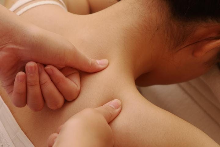 A therapist pressing muscles on the patient's back