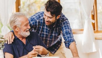 A senior man eating foods to lower HDL cholesterol with his young adult son