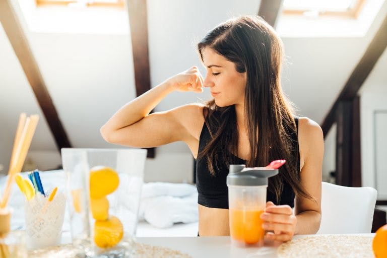 A woman with a strong immune system drinks vitamin C-rich orange juice.